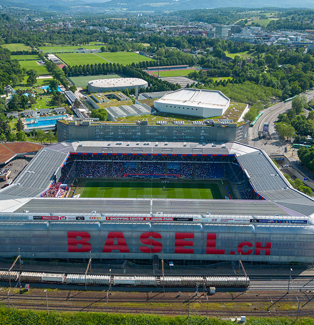 Das rot/blau beleuchtete FCB Stadion aus der Vogelperspektive.